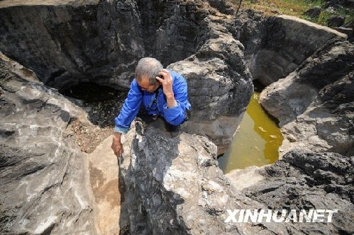 2月23日，黔西南布依族苗族自治州敬南鎮巴布村村民代仲奎在已干枯的水塘邊撓頭。新華社記者 劉續 攝