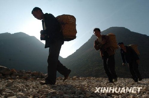 2月22日，在廣西隆林縣徳峨鄉常么村，村民從山洞里取地下水后背水回家。新華社記者 黃孝邦 攝